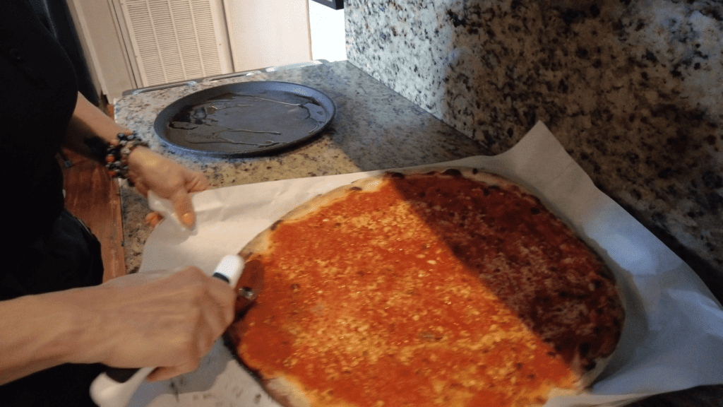 photo of a Frank Pepe original tomato pie being sliced